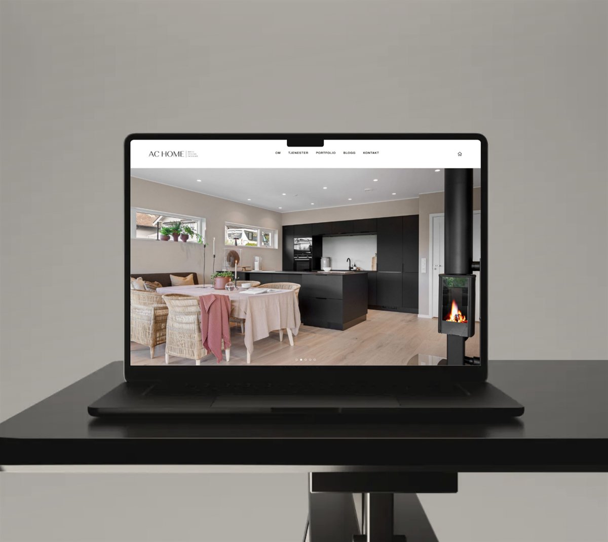 Laptop med nettsiden til AC Home på et marmorbord